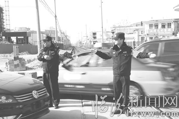 鐵路民警在道口指揮交通,確保車輛安全通行